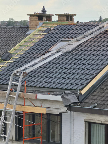 Ouvriers qui rénovent la toiture d’une maison pour isolation et remplacement des tuiles