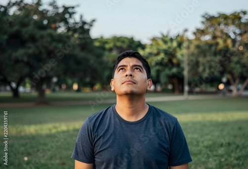 Mindfulness and reflection, man looking up at the sky with hope and inspiration in a park for mental health awareness and personal growth in nature