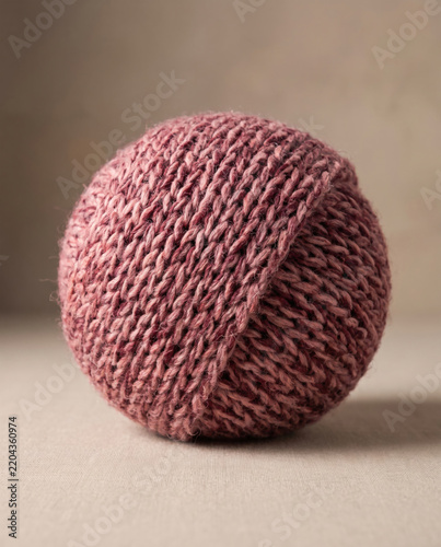 Hand knitted yarn sphere with tactile texture.
