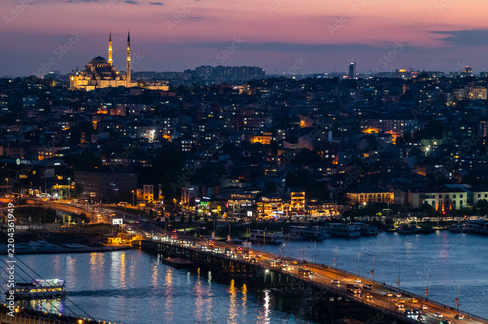 Fototapeta premium Istanbul skyline at night, lit bridges over water, mosques shine