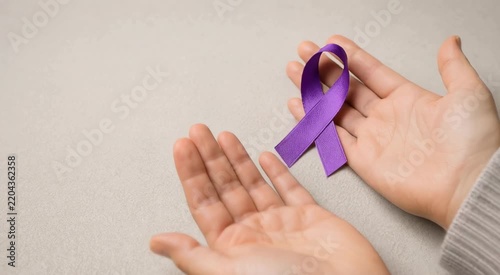 Cupped hands gently holding a purple awareness ribbon symbolizing support, hope, compassion, and charitable advocacy