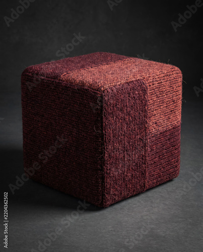 Knitted fabric cube with textured surface.