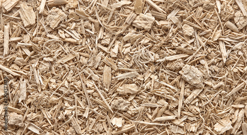 Fine grain husk fractions create a dry beige particulate surface with varied elongated fragments