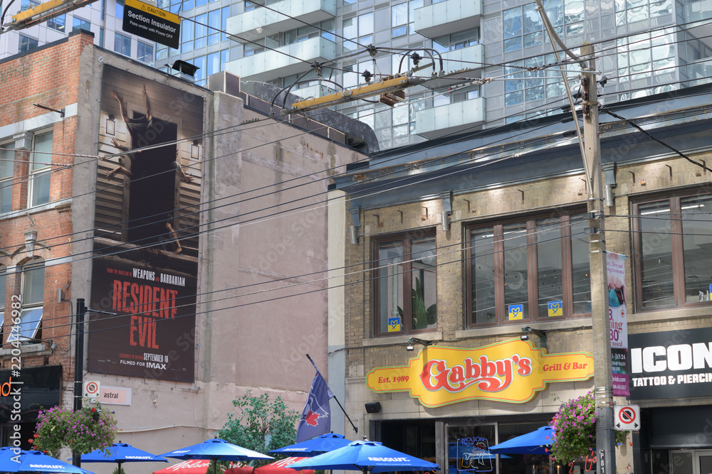 Obraz premium billboard with film promotion and signs of Gabby's - King West, a restaurant and Icon Tattoo and Piercing, 309 King St W, Toronto