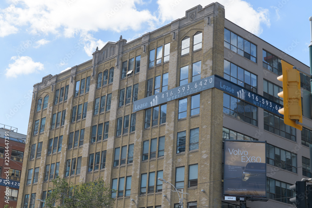 Obraz premium roadside billboard advertising a Volvo vehicle and facade of Fashion Building (126 Spadina Av) designed by Benjamin Brown and Kaplan & Sprachman, Toronto
