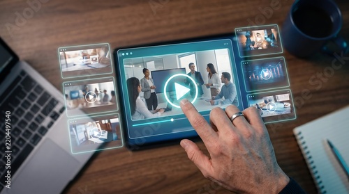 Finger touching digital screen displaying multiple professional corporate training videos