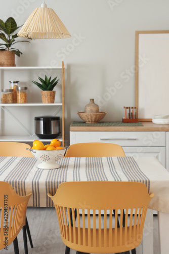 Colander with lemons on dining table in kitchen