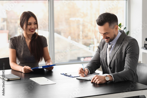 Human resources manager interviewing female applicant at table in office