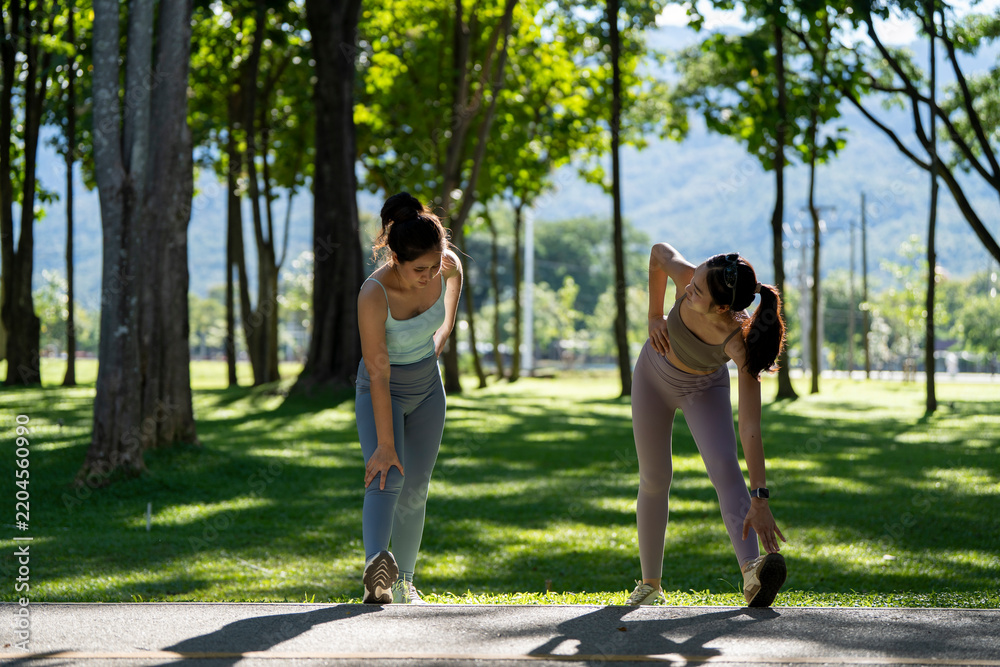 Fototapeta premium Young women stretching preparing for outdoor exercise