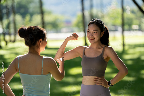 Young asian women flexing biceps showing strength