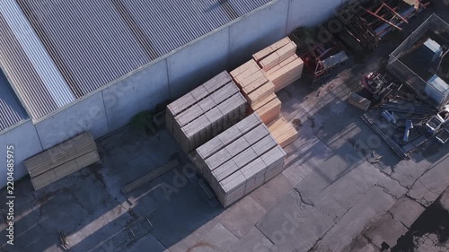 Aerial view of a lumber yard with stacked timber and moving shadows