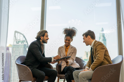 Business colleagues laughing over tablet during informal meeting