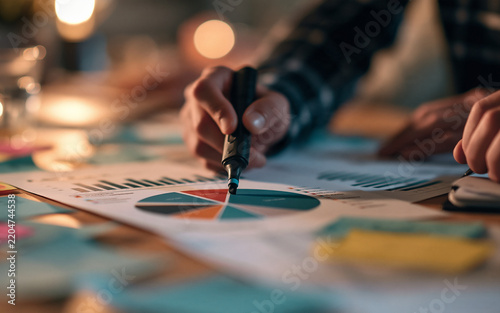 Close up of a hand drawing on a colorful pie chart, data analysis and business reporting concept, vibrant analytics report photography