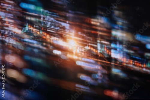 Blurred abstract financial market data and fintech trading charts with glowing digital lights