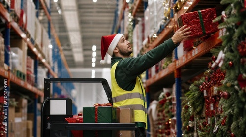 Warehouse Worker in Santa Hat Packing Christmas Gifts