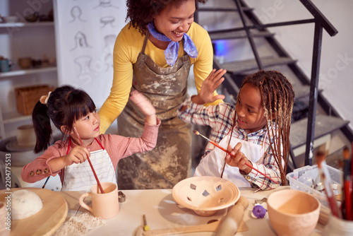 Happy kids and smiling teacher creating art Together at pottery workshop.  Creative, hobby ,activities concept