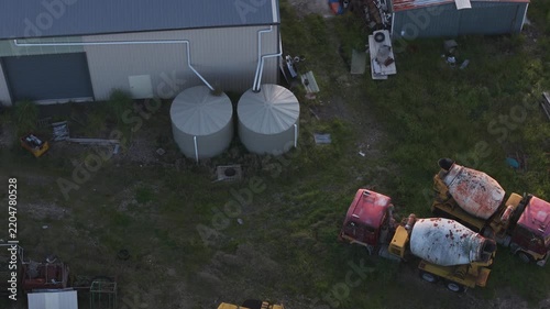 Aerial view of rusty old concrete mixer trucks in a junkyard