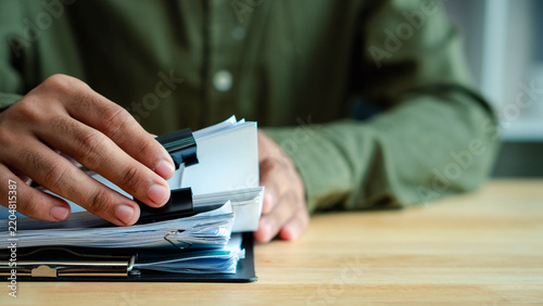 paperwork, document,office,Business professional reviewing and sorting paperwork at an office desk, representing document management, administrative workload, compliance review and corporate workflow.