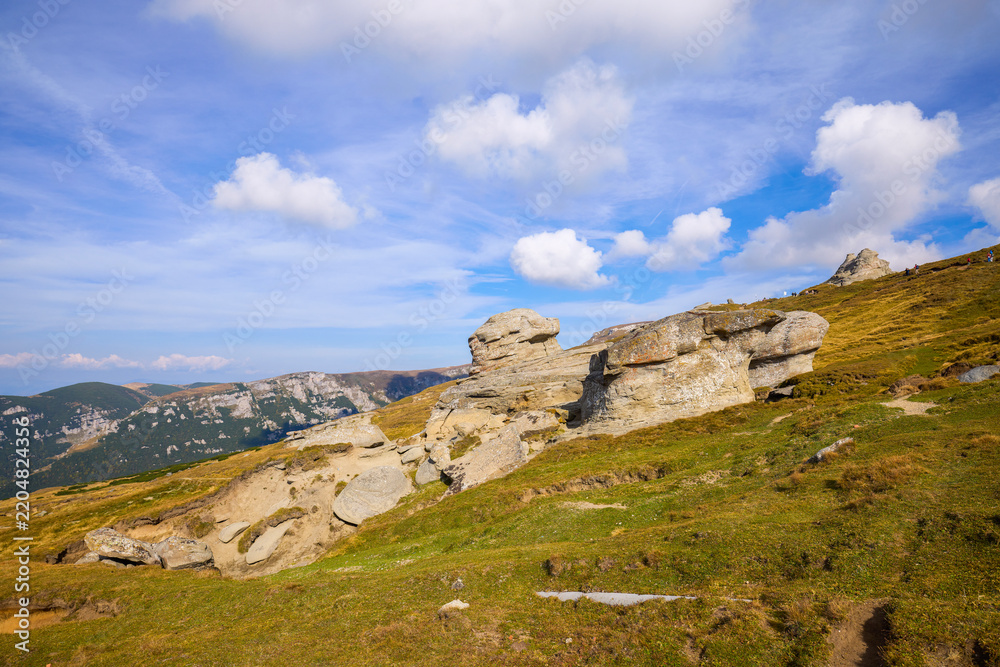 Fototapeta premium A beautiful mountain landscape in the Bucegi Mountains (part of the Carpathians in Romania), featuring various rock formations shaped by the erosion of time, wind, and mountain rains.