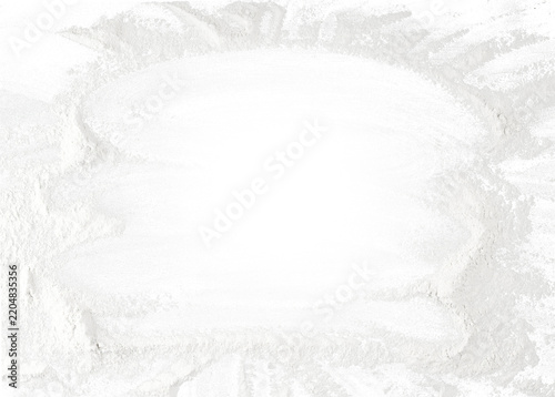 Texture of scattered white wheat flour with smudges and traces on the surface