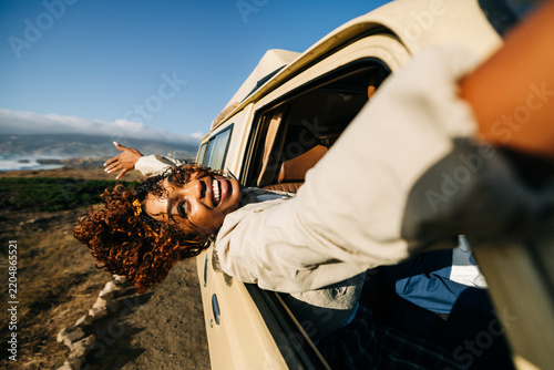 Happy woman leans from car window during road trip adventure