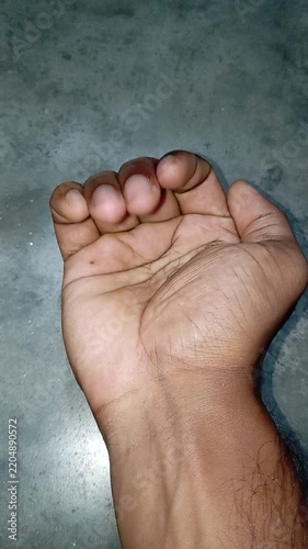 Close Up of a Human Hand Uncurling Fingers One by One from a Fist