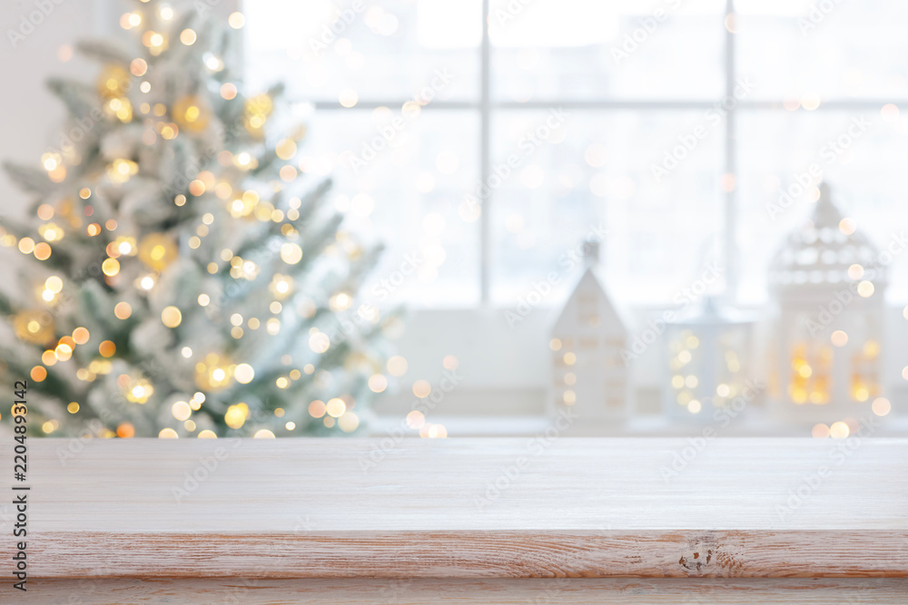 Obraz premium Light wooden table top with blurred Christmas tree and festive background for holiday product display