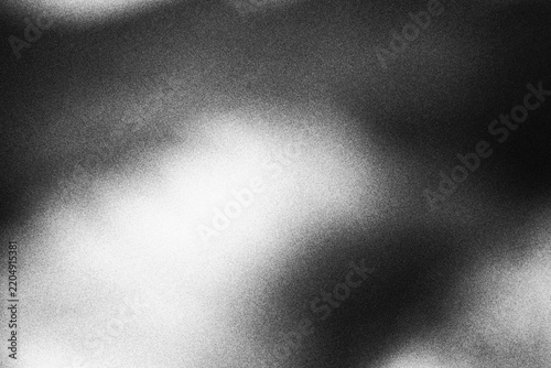 Abstract black and white grainy texture background with soft light