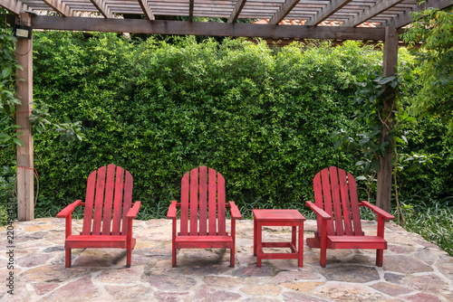 Obraz na plátně Three red wooden armchairs decorated in tropical garden