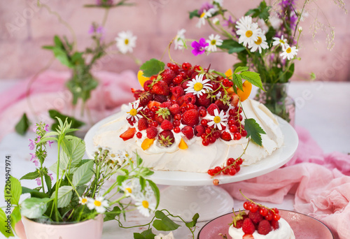 Delicious Pavlova meringue cake decorated with fresh summer berries