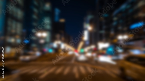 Abstract motion blur of city street at night with skyscrapers an