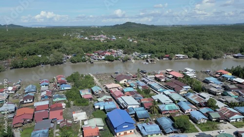 Aerial view of a riverine village with colorful houses along the riverbank in Sarawak, Malaysia.