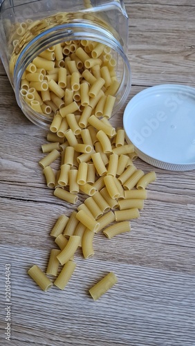 Pasta spilled from a jar onto the table