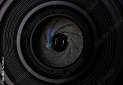 Camera Lens Aperture Blades Macro Close-Up,A detailed macro close-up photograph looking directly into a camera lens, featuring the aperture blades, optical glass, and green anti-reflective coating. 