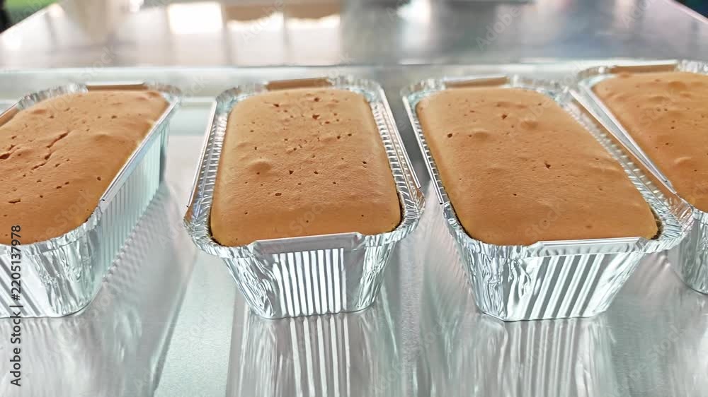 Freshly baked butter loaf cakes in aluminium foil containers. Stock ...