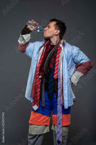 Thirsty overdressed man drinking water from a plastic bottle