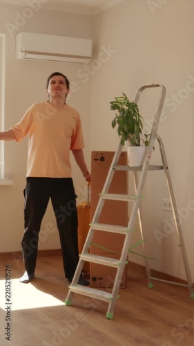 Young man standing in minimalist dormitory room with backpack