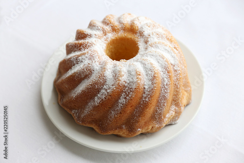 Fotografía Homemade lemon bundt cake with icing sugar against white background