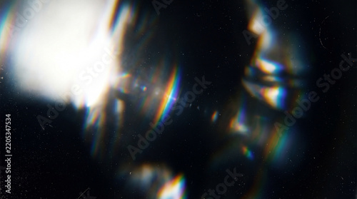 A high-quality abstract optical lens flare effect featuring rainbow chromatic aberrations and subtle vintage film grain on a dark background.