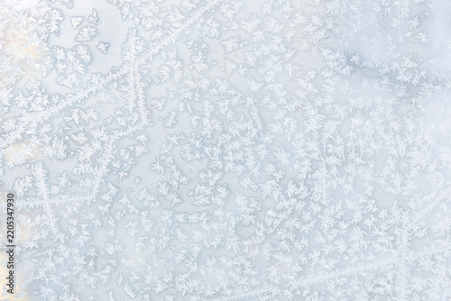 Cool-toned frosty ice patterns and snowflakes on window glass