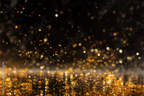 Macro photo of gold glitter sparkles on isolated black background