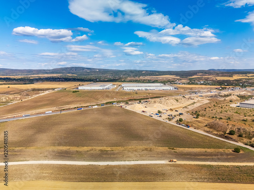 Aerial view of M1 highway widening in Hungary beside industrial parks.