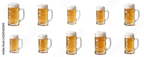 Multiple beer steins filled with golden beer and white foam against black background