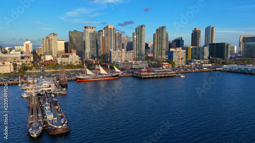 Aerial view of the San Diego skyline and waterfront, featuring historic sailing ships docked at the North Embarcadero and modern skyscrapers in San Diego, California, United States.