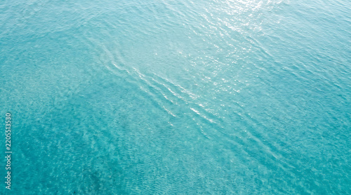 Aerial view of clear turquoise tropical ocean water surface with tropical sea