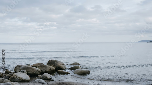 Rocky shoreline at the edge of the ocean under a cloudy sky with rocky shore