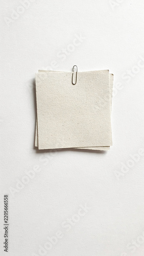 Minimalist stack of textured paper clipped on bright surface with minimalist stationery recycled fastener material business background organizer workshop resource as PNG cutout