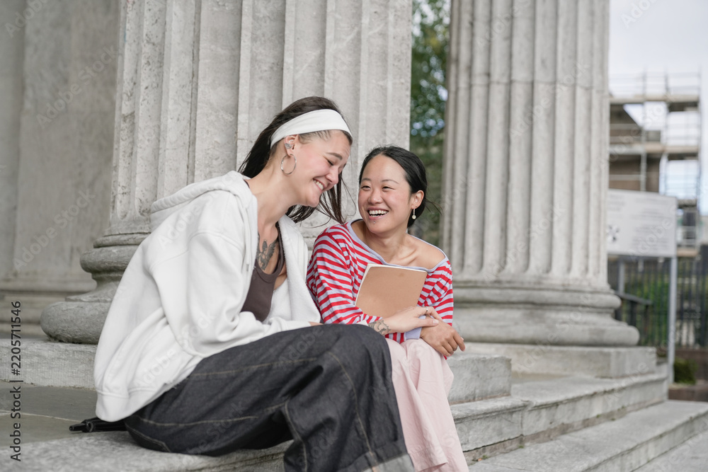 Obraz premium Diverse students laughing sharing moment on campus