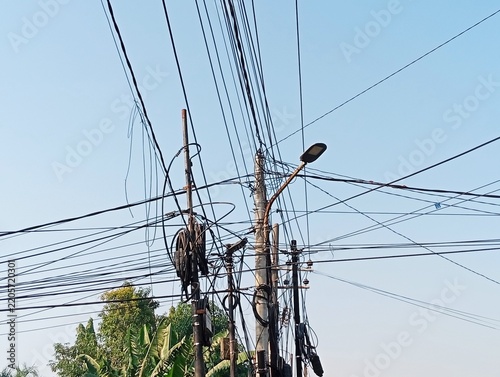 Chaotic Web of Tangled Electrical and Internet Cables on Urban Utility Poles