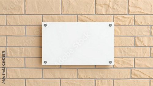 Empty white rectangular sign board mounted on a textured orange brick wall